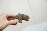 Vintage African bronze hippo held in hand to illustrate its scale and texture.