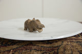 Close-up on the rustic, textured face and open mouth of a vintage bronze hippo.