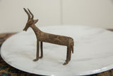 Vintage African bronze antelope sculpture with a wavy patterned body and slender legs.