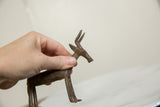 Vintage African bronze antelope held in hand to show its scale and slender profile.