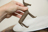 Vintage African bronze antelope held in hand to show its collectible scale and textured patina.