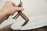 A hand holding the vintage African bronze antelope, highlighting its size and texture.