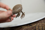 View from underneath the vintage bronze bustard, focusing on its textured legs and feet.