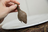 Vintage bronze Kori bustard bird held to show scale and its etched crosshatch texture.