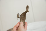 Angled view of the vintage African bronze bird's textured body and fanned tail.