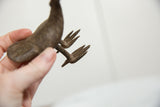 Close-up of the splayed bronze feet on the handmade vintage bird sculpture.