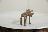 Vintage bronze warthog sculpture showing its textured back and curved tail.