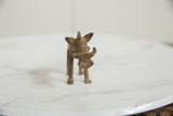 Head-on view of a vintage bronze warthog figure highlighting its handmade tusks and ears.