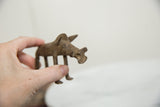 Hand holding the vintage African bronze warthog, highlighting its aged texture.