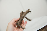 Vintage bronze warthog sculpture held in hand, revealing its scale and textured patina.