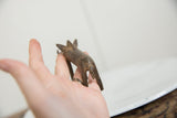 Vintage bronze warthog held in hand to show its small scale and handmade texture.