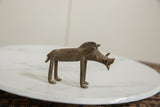 The distinctive silhouette and aged bronze patina of a handmade warthog sculpture.