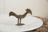 Side profile of a handmade African bronze bird showing its long tail and crested head.