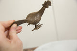 A hand holding the African bronze bird, illustrating its size and textured finish.
