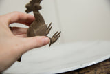 A close-up of the vintage African bronze bird's cast feet and textured body.