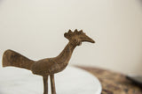 Close-up of the vintage bronze bird's head, showing its textured comb and incised neck patterns.