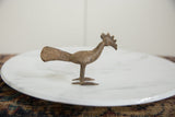 Patinated bronze bird head with textured comb and pointed beak.