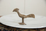 Vintage African bronze bird sculpture in profile, showing its textured finish and long tail.