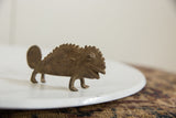 Side view of a vintage African bronze chameleon, highlighting its rugged, textured body.