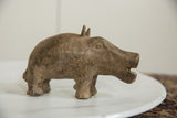 Vintage bronze hippo figure seen in profile, showing its rough, handmade texture and open mouth.