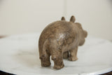 Rear view of the vintage bronze hippo, focusing on its textured back and tail.