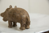 Rear view of a vintage bronze hippo highlighting its stout form and textured surface.