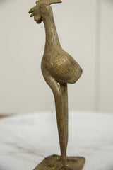 Etched details and aged patina on the body and neck of a long-legged African bronze bird.