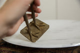 Textured bronze and etched lines on the square base of a vintage African bird figure.