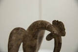 Aged patina on the scrolled comb and neck of a vintage African bronze bird.