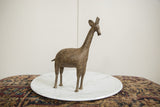Side profile of a handmade African bronze giraffe with intricate circular patterns.