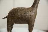 Aged bronze patina and textured concentric circle pattern on the vintage giraffe's body.