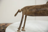 The aged bronze patina on the tail and hind legs of the vintage warthog figure.