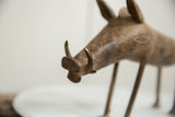 Angled close-up of the bronze warthog's snout and tusks showing handmade texture.