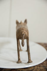 Rear view of the vintage bronze warthog, focusing on its tail and aged patina.