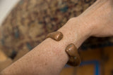 A model wears the antique copper snake cuff, showing its fit and rich patina.