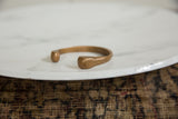Side profile of the antique African copper bracelet highlighting its handcrafted, open cuff form.