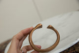 Antique copper snake bracelet held to show its handcrafted form and warm, aged patina.