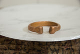 Flared terminals of the antique copper snake bracelet showing its warm, handcrafted patina.