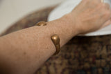 Antique African copper snake bracelet styled on an arm to show scale and fit.