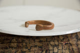 The open cuff and rustic texture of an antique African copper snake bracelet.
