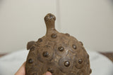 Vintage African bronze turtle, featuring spiral eye details and raised circular shell patterns.