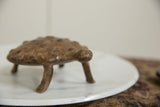 Low angle profile of the vintage African bronze turtle's textured head and shell.