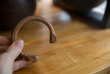 The hand-engraved snake head and warm copper patina of an antique African cuff.