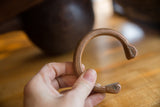 Antique copper snake cuff bracelet held in hand showing its scale and unique form.