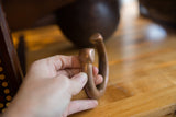 Antique copper snake cuff bracelet held in hand to show its size and form.