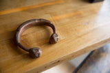 Angled profile of an antique copper snake cuff with stylized geometric ends.