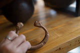 Antique copper snake cuff bracelet held in hand, displaying its unique form and patina.