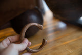 Antique copper snake cuff held to show its substantial form and warm patina.