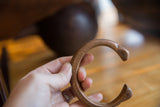 The open C-shape and time-softened patina of a copper snake bracelet.