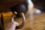 A hand holds the antique copper cuff to display the hand-carved snake head.